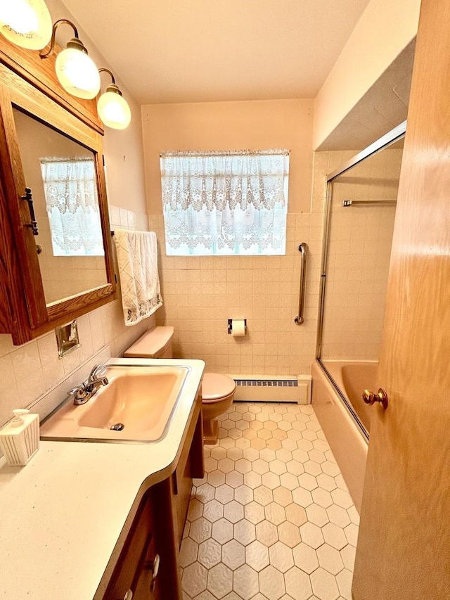 7140 W 64th St, Chicago, IL 60638 - full bathroom featuring a baseboard heating unit, tile walls, toilet, vanity, and enclosed tub / shower combo