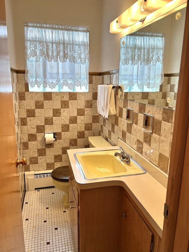 7140 W 64th St, Chicago, IL 60638 - half bath featuring toilet, a baseboard radiator, vanity, tile walls, and tile patterned floors