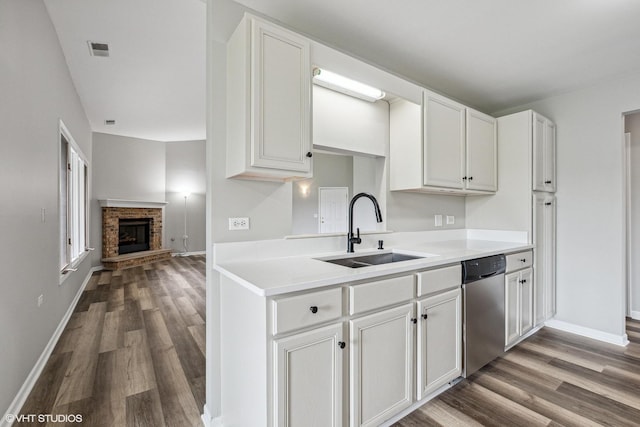 19463 Manchester Dr Unit 2, Mokena, IL 60448 - kitchen featuring a sink, stainless steel dishwasher, dark wood finished floors, a brick fireplace, and light countertops