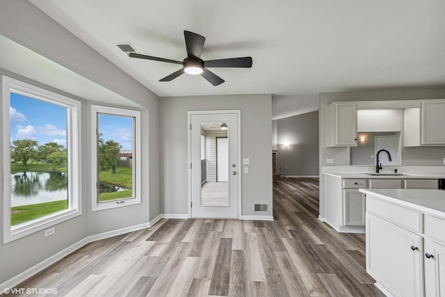19463 Manchester Dr Unit 2, Mokena, IL 60448 - kitchen with a sink, light countertops, a ceiling fan, light wood-style flooring, and white cabinets