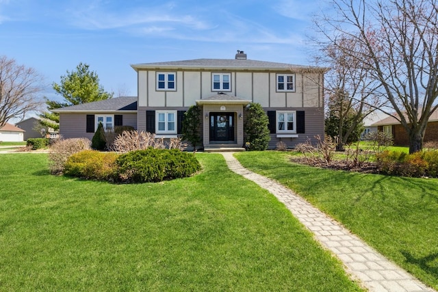 230 S Constitution Dr, Aurora, IL 60506 - tudor house featuring a front lawn and a chimney