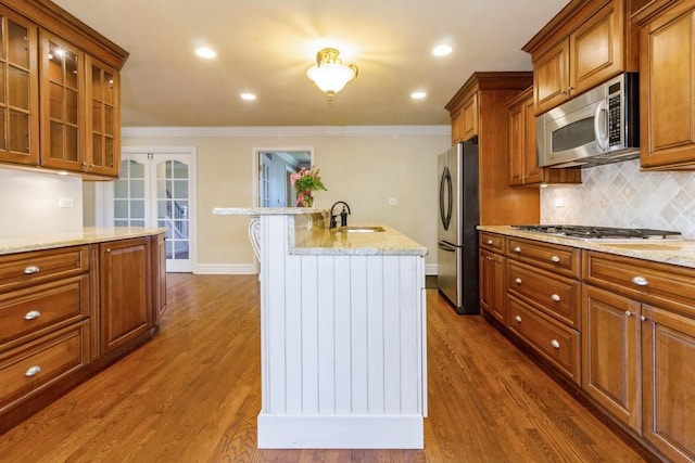 230 S Constitution Dr, Aurora, IL 60506 - kitchen with appliances with stainless steel finishes, a sink, brown cabinetry, backsplash, and light stone countertops