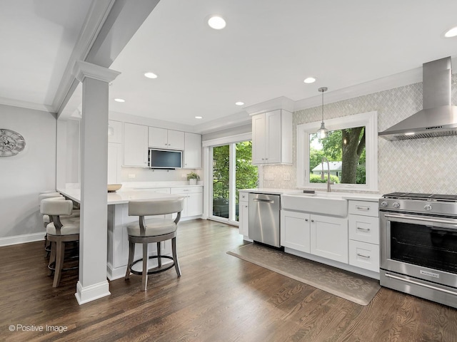 1465 Cantigny Way, Wheaton, IL 60189 - kitchen with appliances with stainless steel finishes, wall chimney exhaust hood, a sink, light countertops, and baseboards