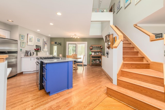 228 Cornell Ave, Des Plaines, IL 60016 - kitchen with appliances with stainless steel finishes, blue cabinetry, white cabinets, a kitchen island, and recessed lighting
