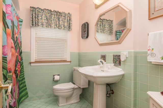 228 Cornell Ave, Des Plaines, IL 60016 - bathroom with tile walls, a wainscoted wall, tile patterned flooring, toilet, and a shower with shower curtain