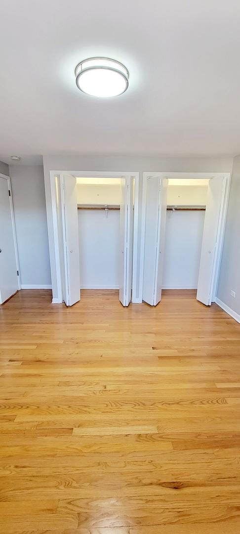 1353 Perry St Unit 6, Des Plaines, IL 60016 - unfurnished bedroom featuring light wood-type flooring, baseboards, and multiple closets