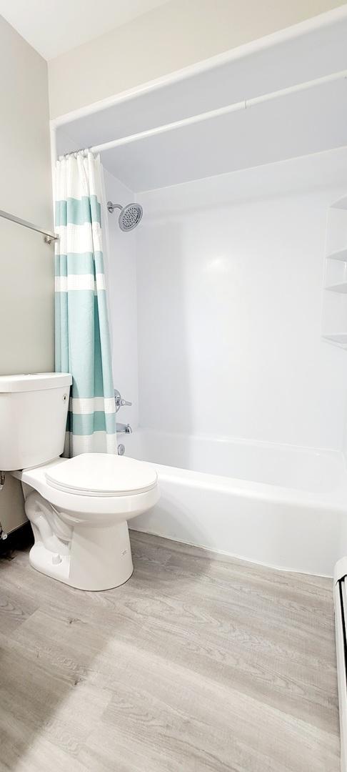 1353 Perry St Unit 6, Des Plaines, IL 60016 - bathroom with toilet, wood finished floors, shower / bath combination with curtain, and a baseboard radiator