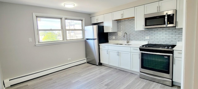 1353 Perry St Unit 6, Des Plaines, IL 60016 - kitchen featuring stainless steel appliances, a baseboard heating unit, a sink, light countertops, and tasteful backsplash