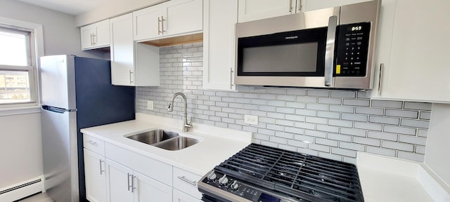 1353 Perry St Unit 6, Des Plaines, IL 60016 - kitchen featuring appliances with stainless steel finishes, a baseboard heating unit, a sink, white cabinetry, and decorative backsplash