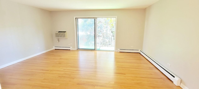 1353 Perry St Unit 6, Des Plaines, IL 60016 - empty room with a baseboard radiator, a wall mounted air conditioner, baseboard heating, light wood-type flooring, and baseboards