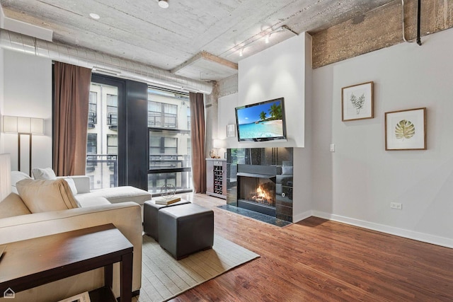 1111 W 14th Pl Unit 211, Chicago, IL 60608 - living area with wood finished floors, a tiled fireplace, and baseboards