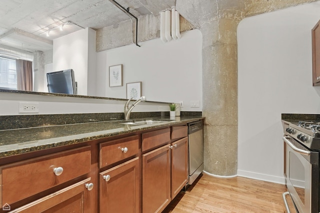 1111 W 14th Pl Unit 211, Chicago, IL 60608 - kitchen with stainless steel appliances, a sink, light wood-type flooring, dark stone counters, and brown cabinets