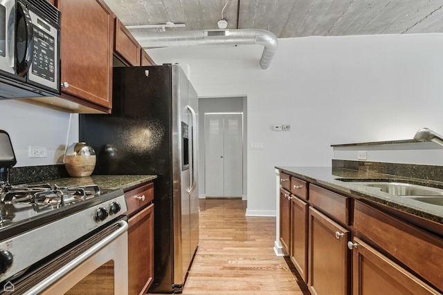 1111 W 14th Pl Unit 211, Chicago, IL 60608 - kitchen with appliances with stainless steel finishes, light wood-type flooring, a sink, dark stone counters, and brown cabinets