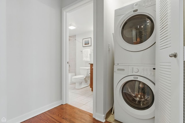 1111 W 14th Pl Unit 211, Chicago, IL 60608 - laundry area with stacked washer and clothes dryer, tile patterned floors, and baseboards