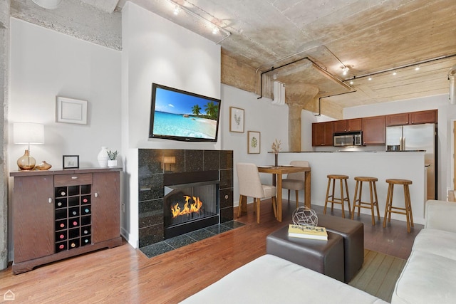 1111 W 14th Pl Unit 211, Chicago, IL 60608 - living area with wood finished floors, rail lighting, and a tile fireplace