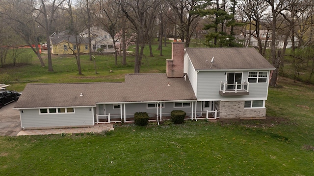 1762 W Palatine Rd, Inverness, IL 60067 - back of property with a chimney, a yard, covered porch, and roof with shingles