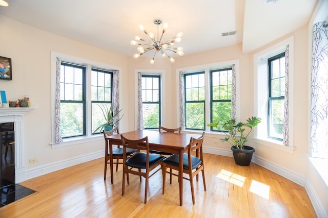 1239 W Jarvis Ave Unit 3, Chicago, IL 60626 - dining space featuring a chandelier, plenty of natural light, and light wood-style flooring