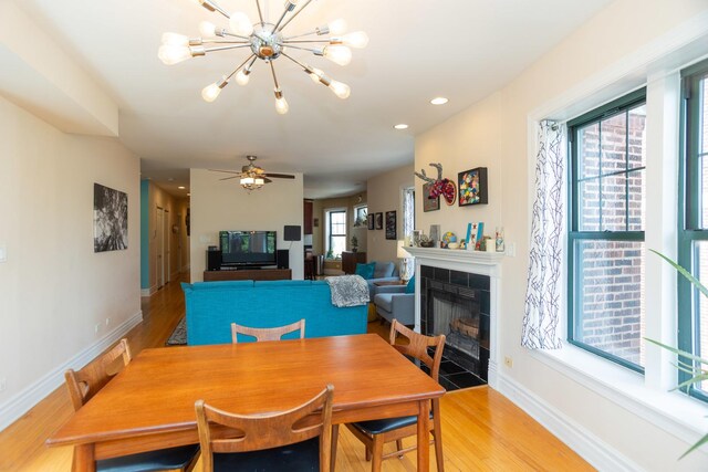 1239 W Jarvis Ave Unit 3, Chicago, IL 60626 - dining room with baseboards, light wood-style floors, a chandelier, a fireplace, and recessed lighting