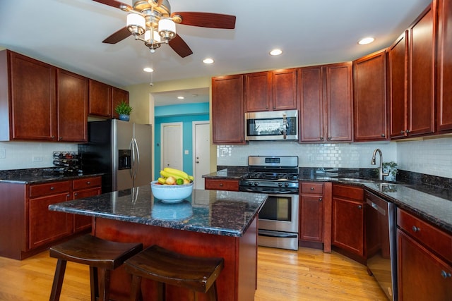 1239 W Jarvis Ave Unit 3, Chicago, IL 60626 - kitchen featuring appliances with stainless steel finishes, a sink, light wood-style flooring, reddish brown cabinets, and recessed lighting