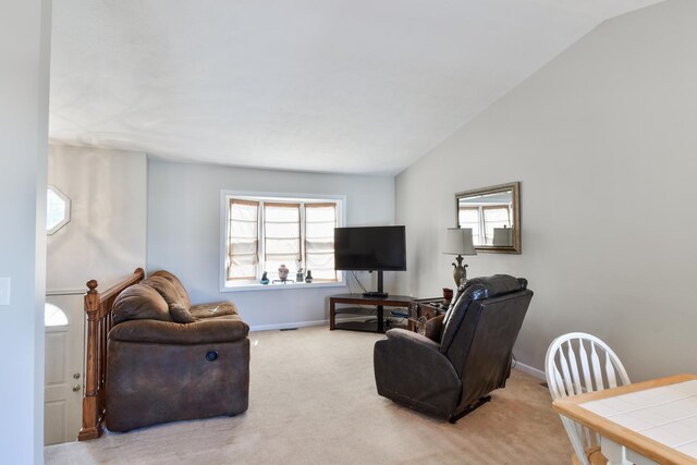 1403 N Motorola Dr, Pontiac, IL 61764 - living area featuring vaulted ceiling, baseboards, healthy amount of natural light, and light colored carpet