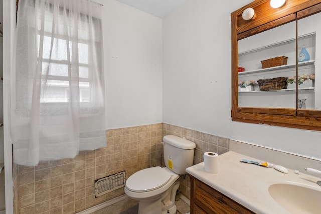 1311 Black Rd, Joliet, IL 60435 - bathroom featuring tile walls, vanity, toilet, and a wainscoted wall