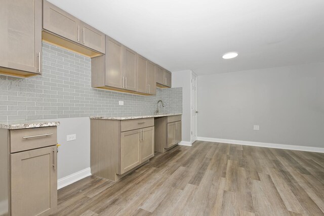 9836 Circle Pkwy, Palos Park, IL 60464 - kitchen featuring light wood-style floors, decorative backsplash, baseboards, and light stone counters