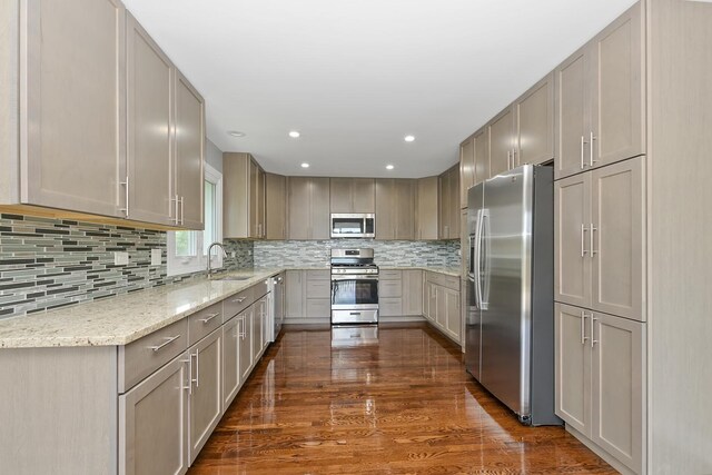 9836 Circle Pkwy, Palos Park, IL 60464 - kitchen featuring appliances with stainless steel finishes, light stone countertops, a sink, dark wood-style flooring, and tasteful backsplash