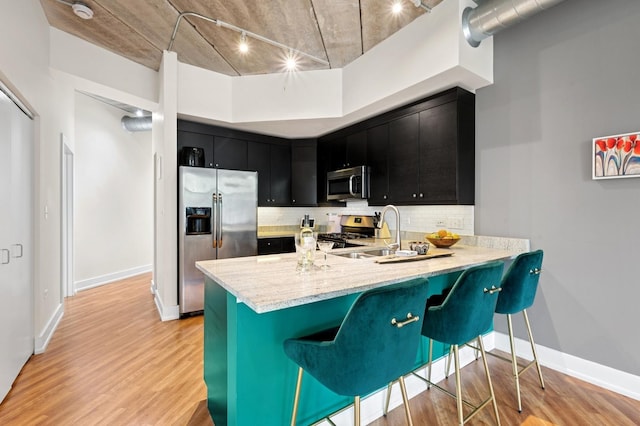 3201 W Leland Ave Unit 205, Chicago, IL 60625 - kitchen with appliances with stainless steel finishes, dark cabinetry, decorative backsplash, a sink, and light wood finished floors