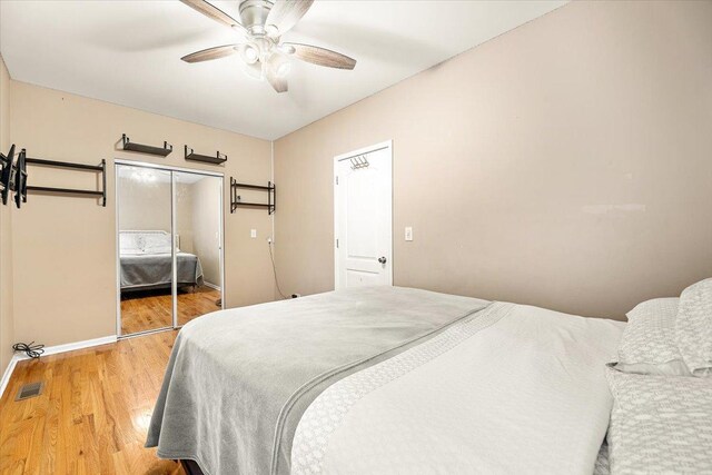 5011 W Deming Pl, Chicago, IL 60639 - bedroom with wood finished floors, baseboards, a ceiling fan, and a closet
