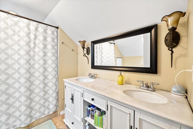 5011 W Deming Pl, Chicago, IL 60639 - full bathroom with double vanity, vaulted ceiling, curtained shower, and tile patterned flooring