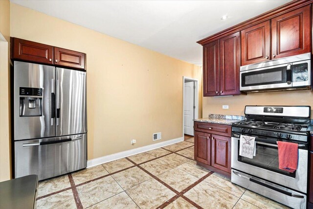 5011 W Deming Pl, Chicago, IL 60639 - kitchen featuring stainless steel appliances, baseboards, and reddish brown cabinets
