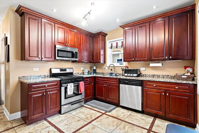 5011 W Deming Pl, Chicago, IL 60639 - kitchen with appliances with stainless steel finishes, dark brown cabinets, and light stone countertops