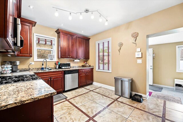5011 W Deming Pl, Chicago, IL 60639 - kitchen with stainless steel appliances, a sink, light stone counters, baseboards, and dark brown cabinets