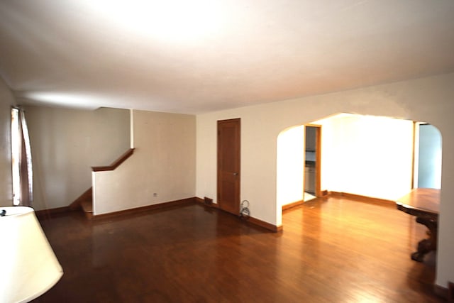 6512 N 2nd St, Loves Park, IL 61111 - unfurnished living room with arched walkways, wood finished floors, stairway, and baseboards