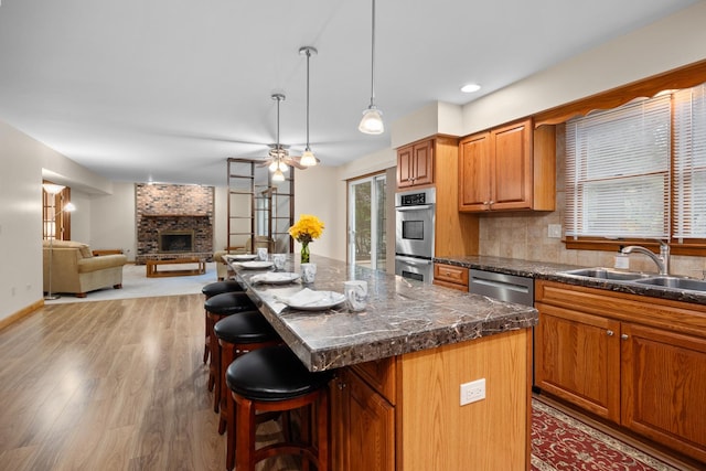 1291 Acorn Ct, Sleepy Hollow, IL 60118 - kitchen with stainless steel appliances, a breakfast bar, a center island, light wood-style floors, and dark countertops