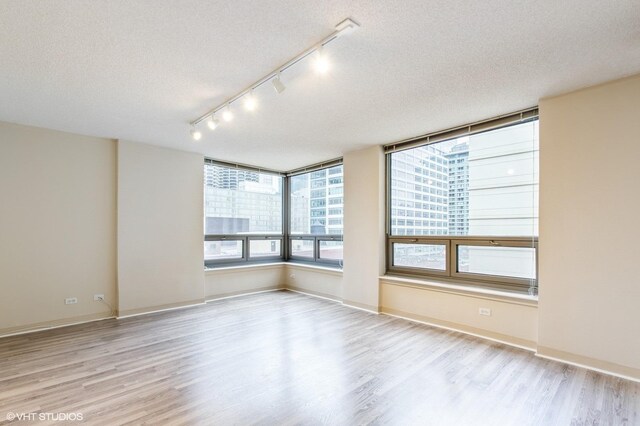 440 N Wabash Ave Unit 1103, Chicago, IL 60611 - spare room featuring rail lighting, wood finished floors, and a textured ceiling