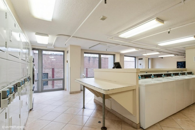 440 N Wabash Ave Unit 1103, Chicago, IL 60611 - kitchen with stacked washer / dryer, light tile patterned flooring, tile counters, independent washer and dryer, and white cabinetry