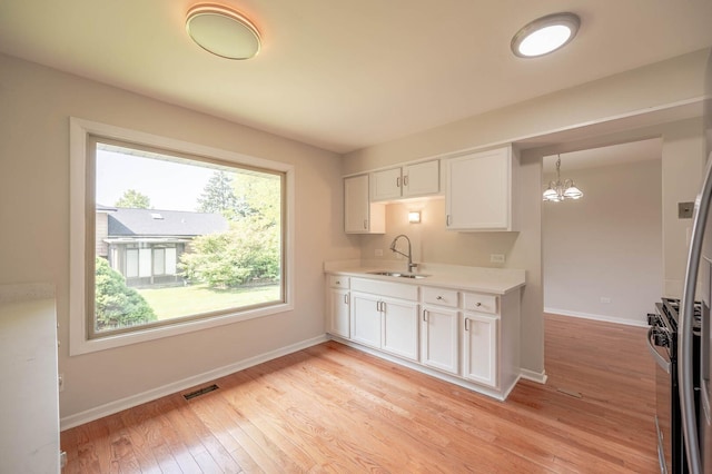 6133 Elm Ln, Matteson, IL 60443 - kitchen with a sink, a chandelier, white cabinets, light countertops, and baseboards