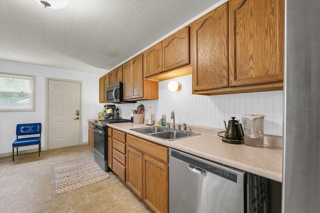 3310 Saratoga Dr, Champaign, IL 61821 - kitchen featuring appliances with stainless steel finishes, a sink, light countertops, and brown cabinets