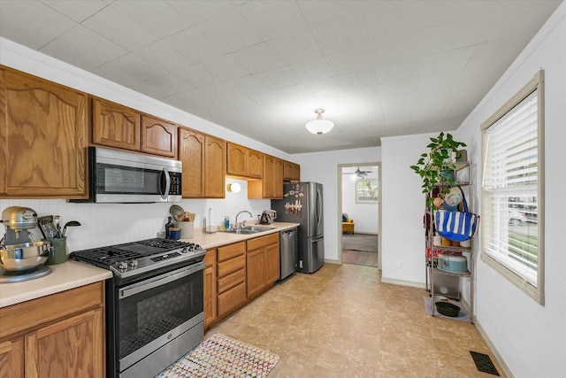 3310 Saratoga Dr, Champaign, IL 61821 - kitchen featuring stainless steel appliances, a sink, light countertops, and brown cabinets