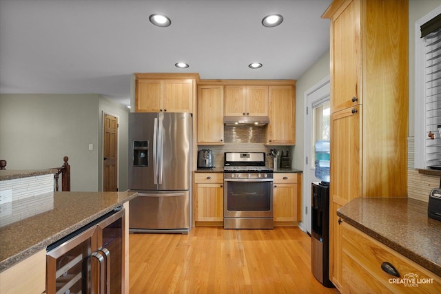 712 Cascade Ave, Romeoville, IL 60446 - kitchen featuring appliances with stainless steel finishes, under cabinet range hood, beverage cooler, backsplash, and light wood-style flooring