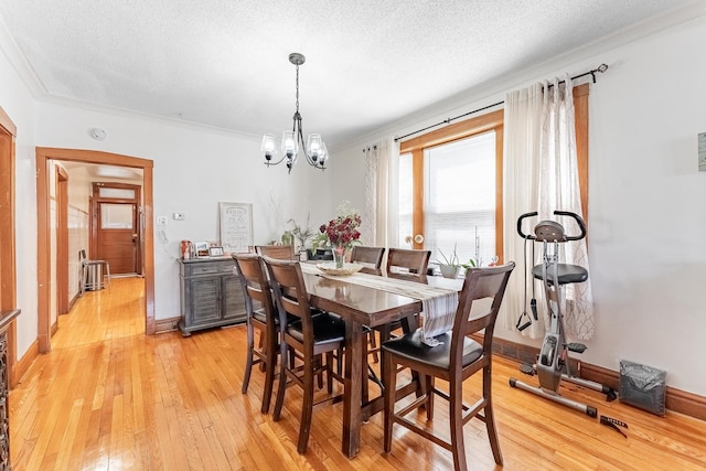 1909 Harvey Ave, Berwyn, IL 60402 - dining area featuring light wood-style floors, a chandelier, crown molding, a textured ceiling, and baseboards