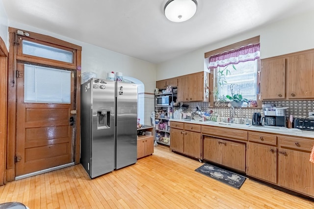 1909 Harvey Ave, Berwyn, IL 60402 - kitchen featuring appliances with stainless steel finishes, light countertops, light wood-style flooring, tasteful backsplash, and a sink