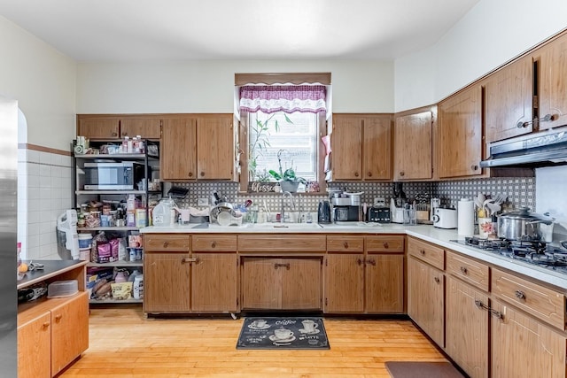1909 Harvey Ave, Berwyn, IL 60402 - kitchen with a sink, stainless steel microwave, light countertops, under cabinet range hood, and decorative backsplash