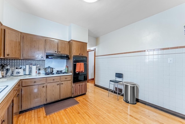 1909 Harvey Ave, Berwyn, IL 60402 - kitchen featuring black oven, tile walls, light countertops, a warming drawer, and under cabinet range hood