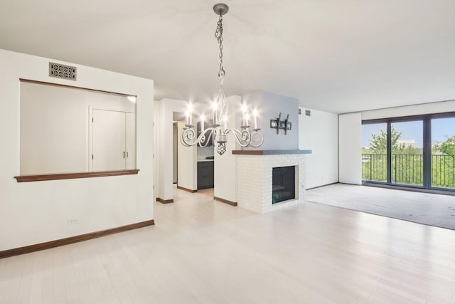 1S150 Spring Rd Unit 5F, Oakbrook Terrace, IL 60181 - unfurnished living room with a chandelier, baseboards, wood finished floors, and a fireplace
