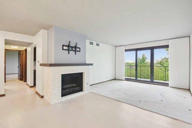 1S150 Spring Rd Unit 5F, Oakbrook Terrace, IL 60181 - unfurnished living room with wood finished floors, a fireplace, baseboards, and a wall of windows