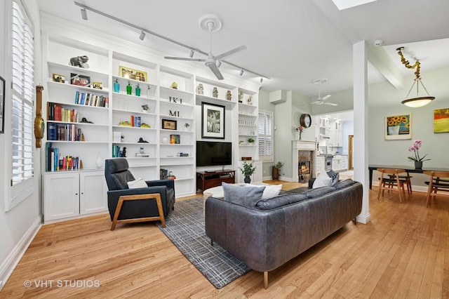 1636 N Cleveland Ave, Chicago, IL 60614 - living area featuring a ceiling fan, track lighting, light wood finished floors, baseboards, and a warm lit fireplace