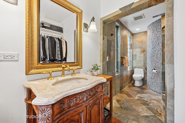 1636 N Cleveland Ave, Chicago, IL 60614 - full bathroom featuring vanity, toilet, stone finish floors, and tiled shower