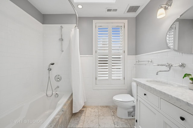 1636 N Cleveland Ave, Chicago, IL 60614 - bathroom featuring tiled shower / bath, tile walls, toilet, vanity, and wainscoting